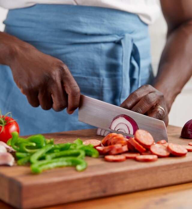 Person chopping vegetables on a cutting board.