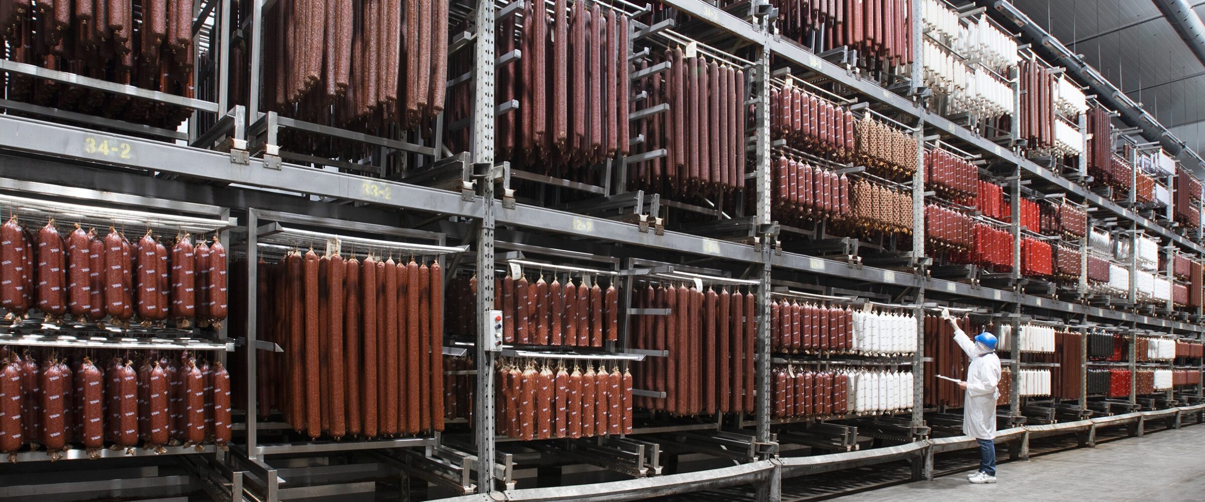Piller's worker doing inventory of meat products in a temperature controlled warehouse.