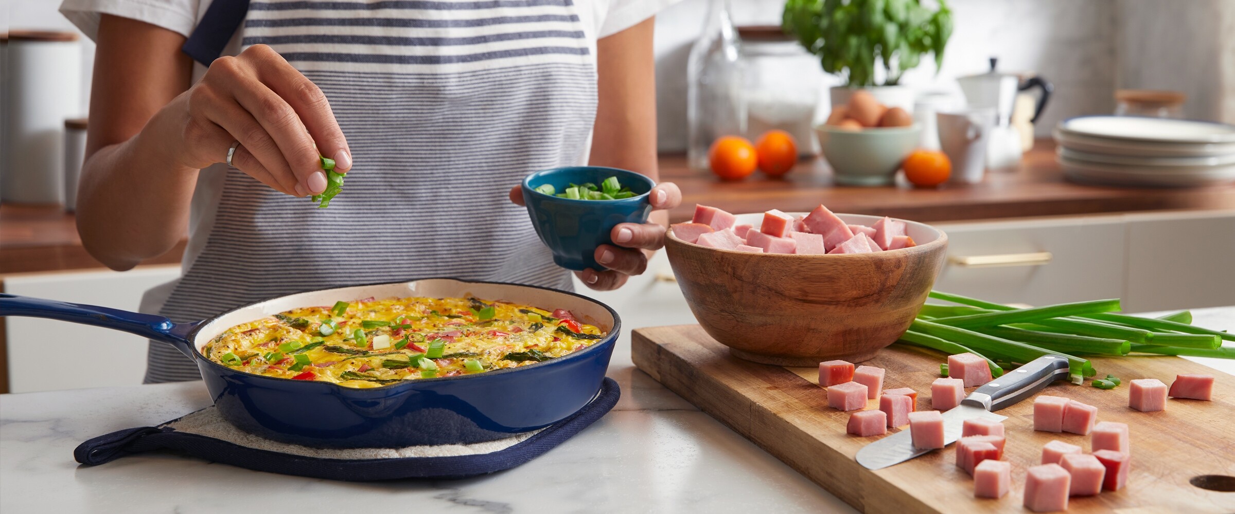 Person making quiche with ham.