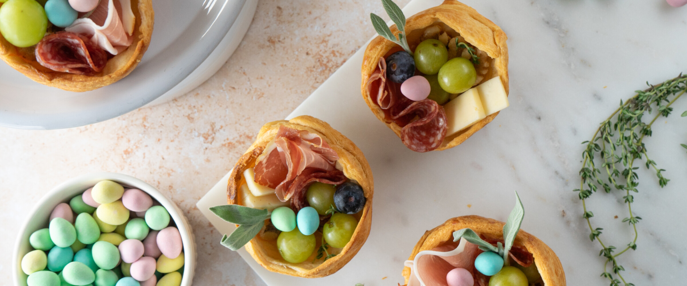 pastry nests filled with charcuterie items on a platter