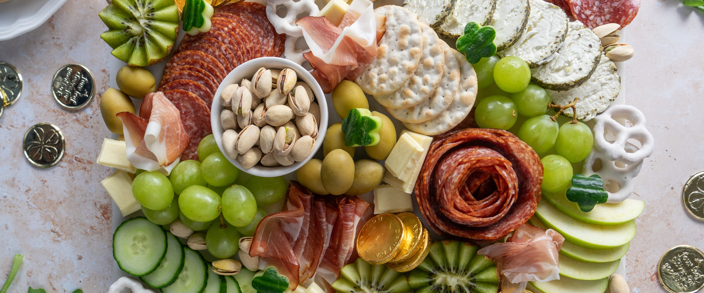 Charcuterie board filled with green and white themed food items for St. Patrick's day