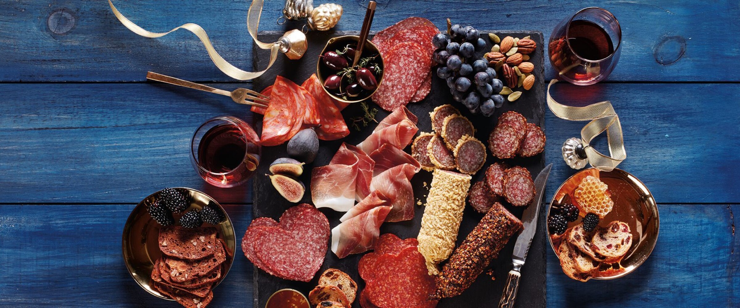 Charcuterie board with shaped salamis, coated salami and with gold ribbon