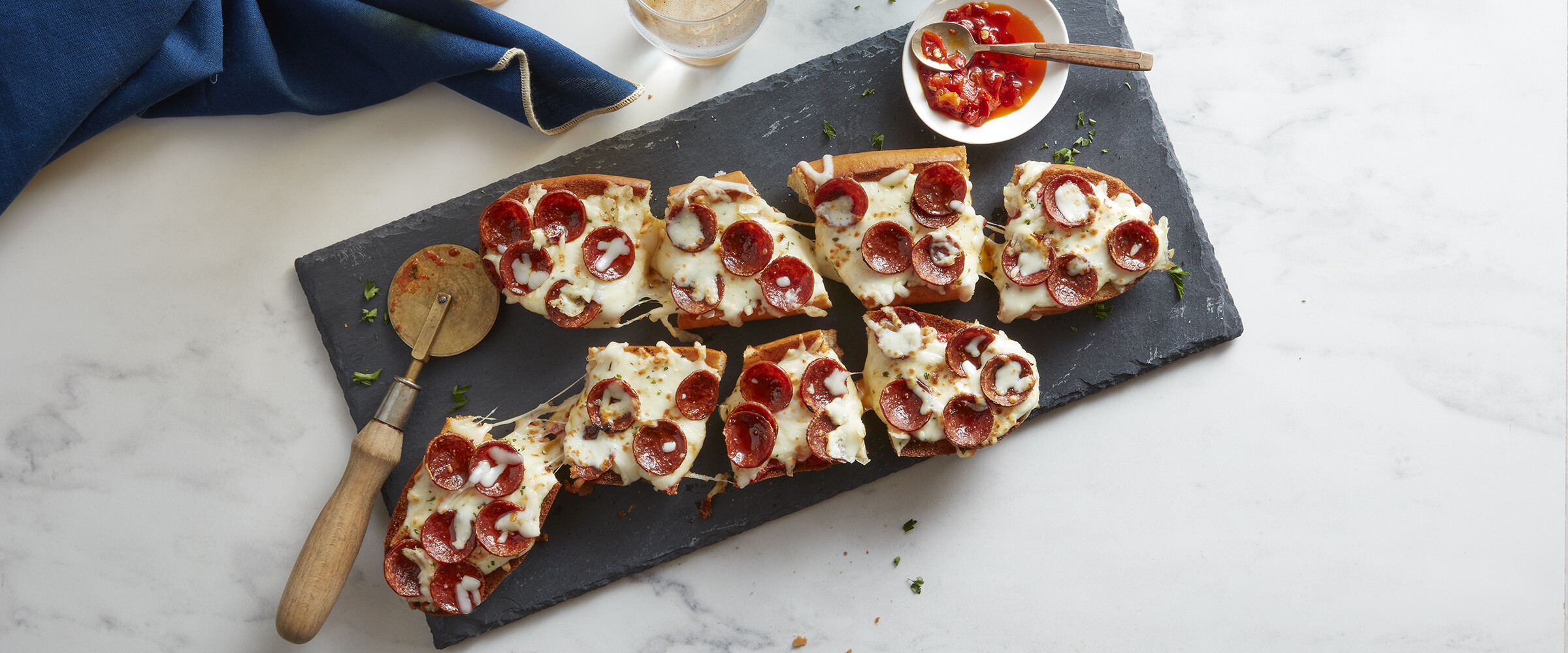 Garlic bread pizza with pepperoni on a black slate