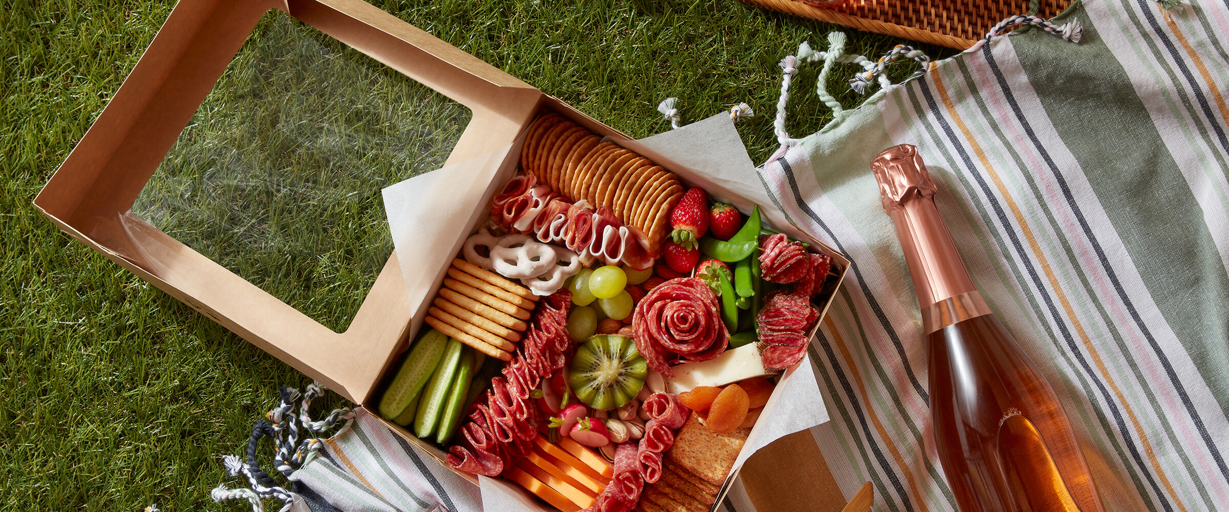 charcuterie grazing box on a picnic blanket