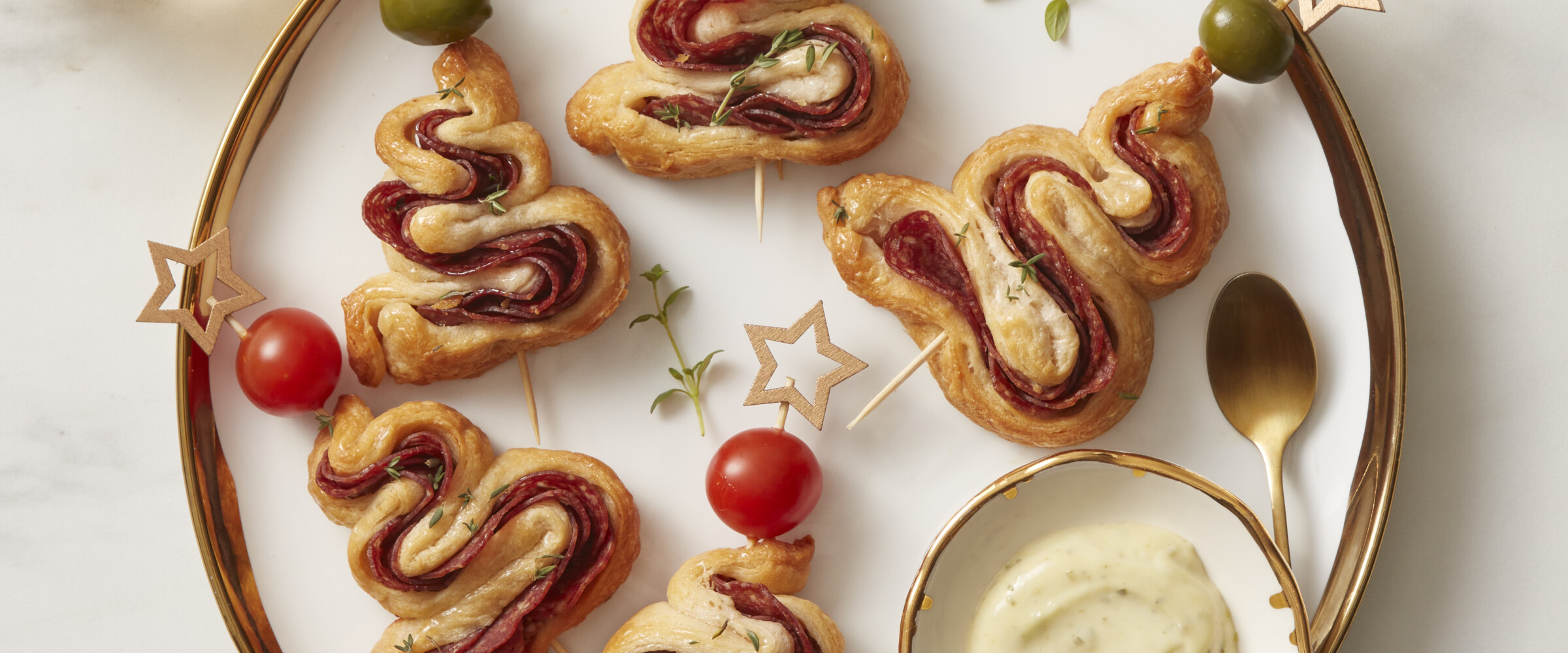 Pastry and salami cooked in the shape of a tree on a serving plate