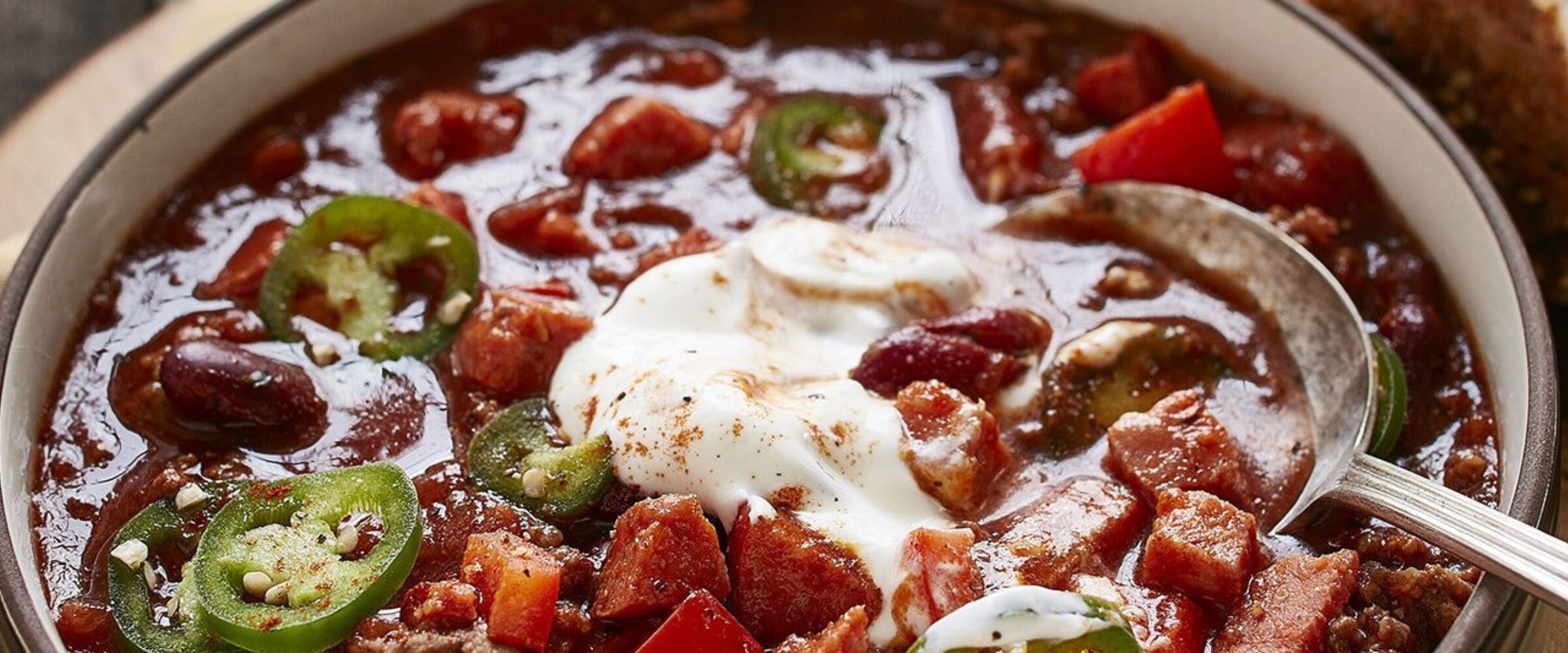 Bowl of chorizo and beef chili with sour cream on top