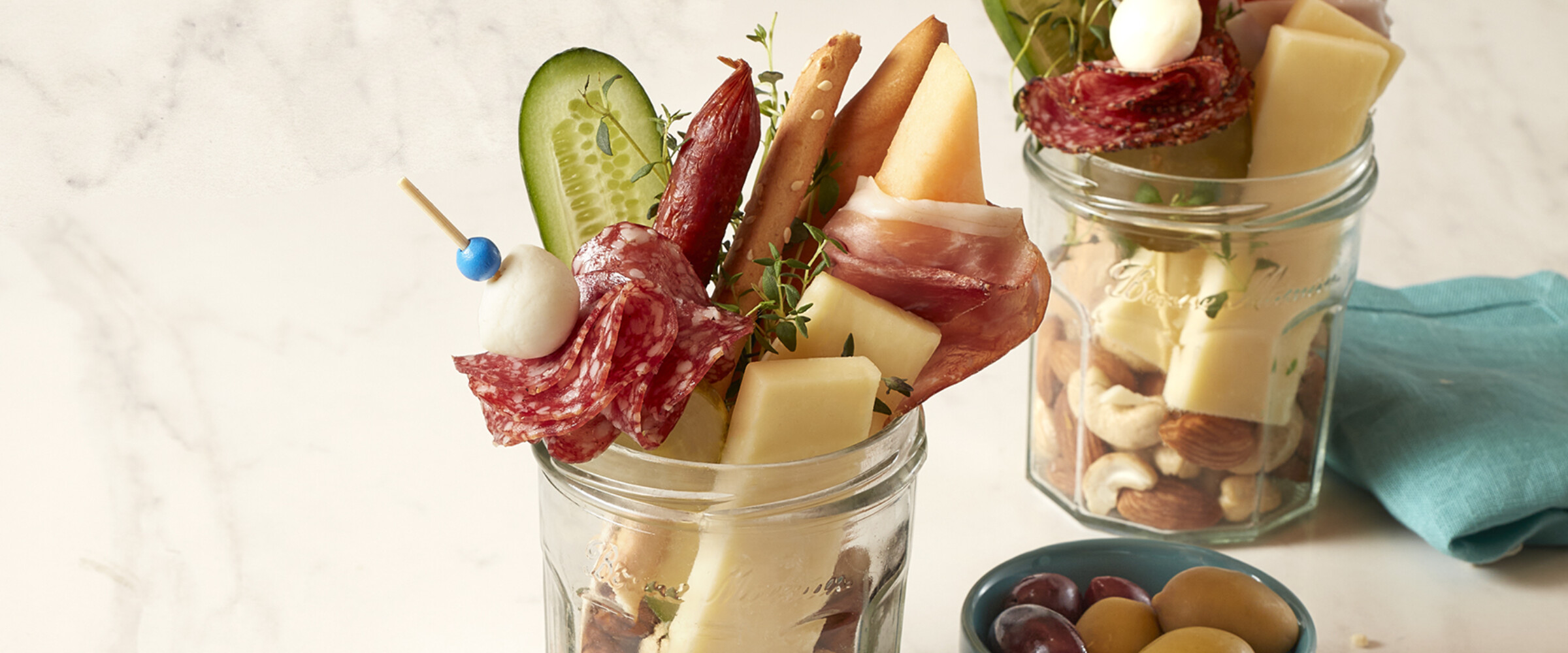 charcuterie inside a mason jar with meat, cheese and nuts