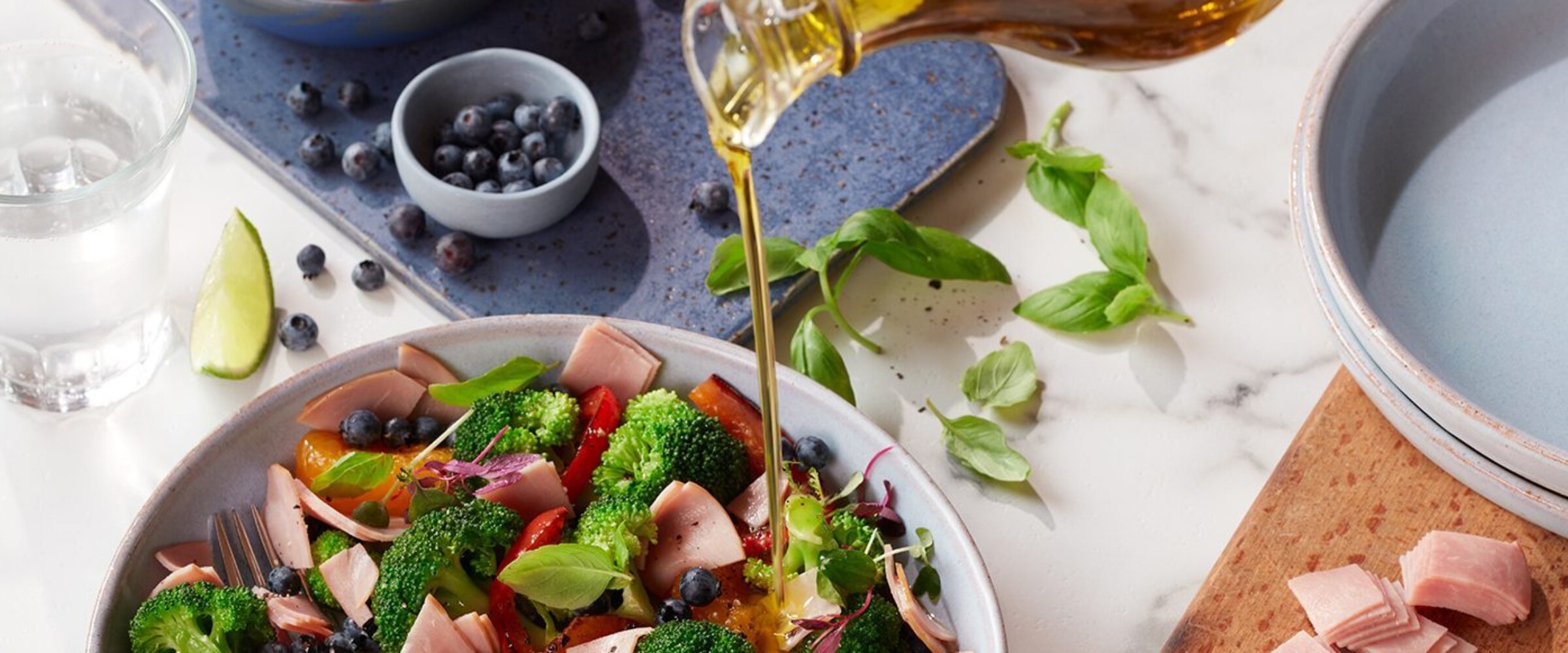 Person pouring dressing on salad