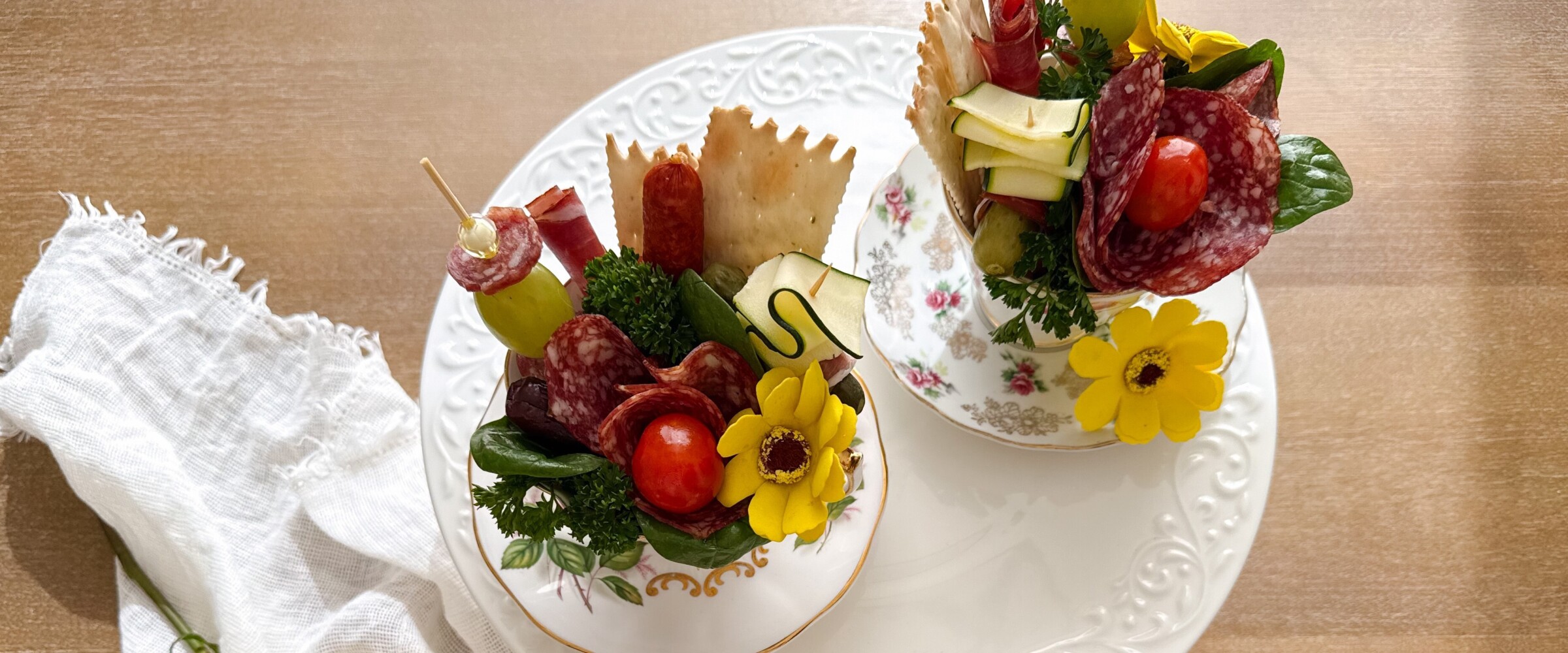 Tea cups with charcuterie items inside of it