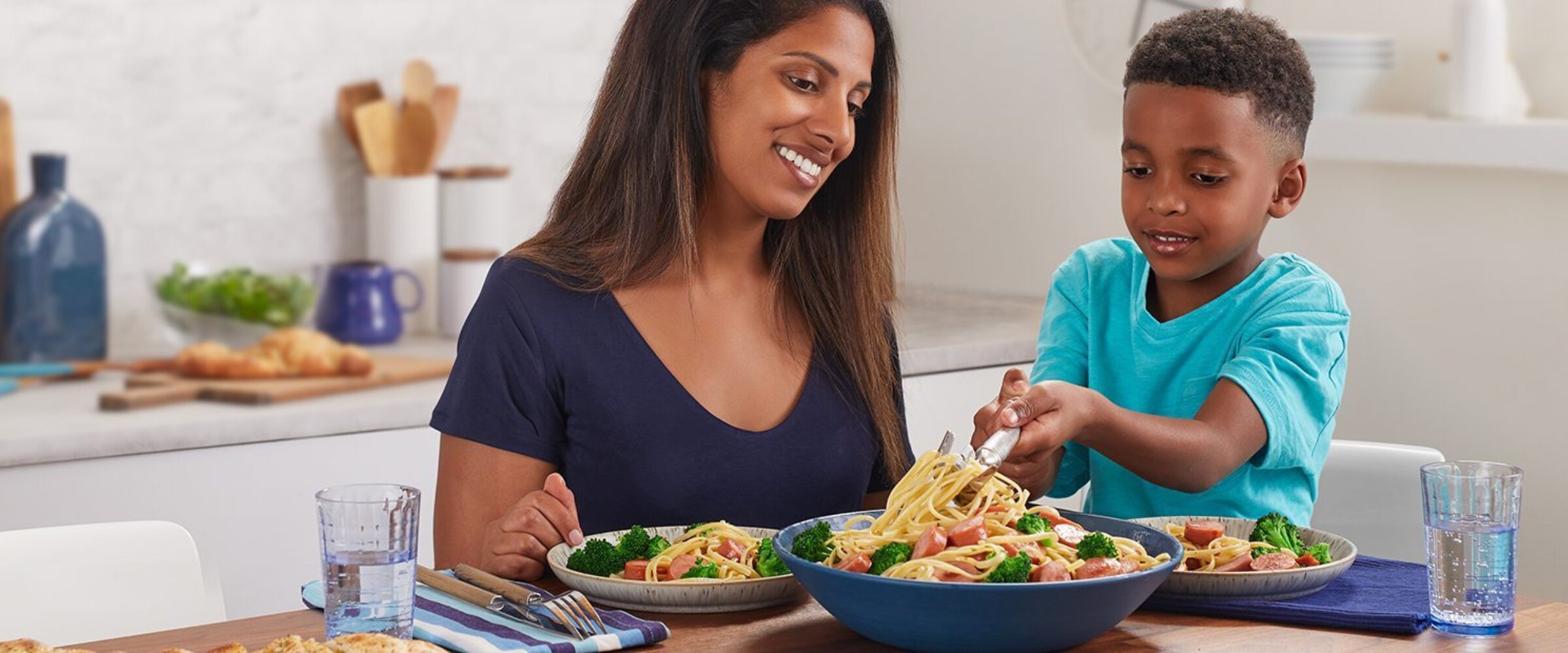 Mom and son scooping pasta