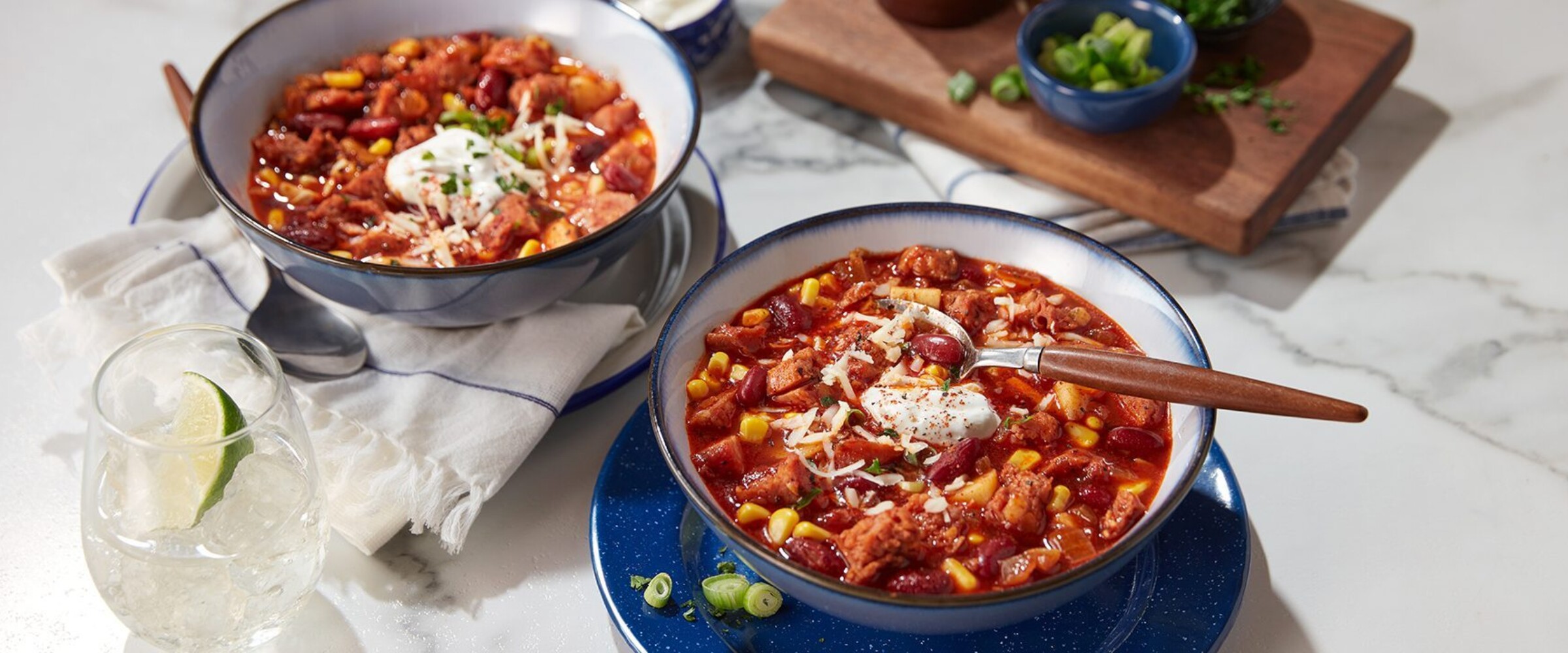 Two bowls of chili with sausage