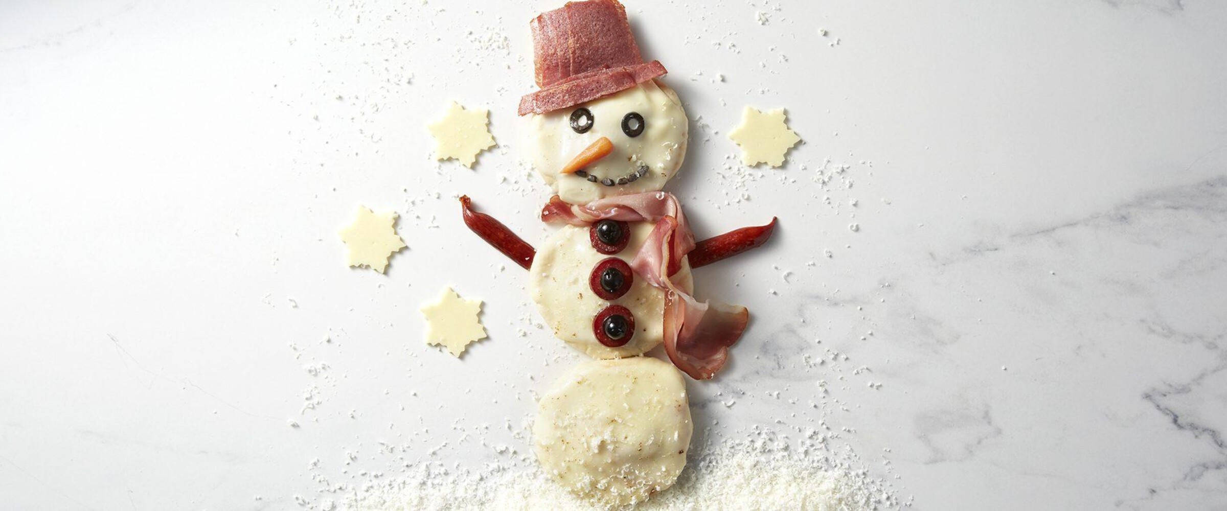 Prosciutto and cheese on pita bread in the shape of a snowman