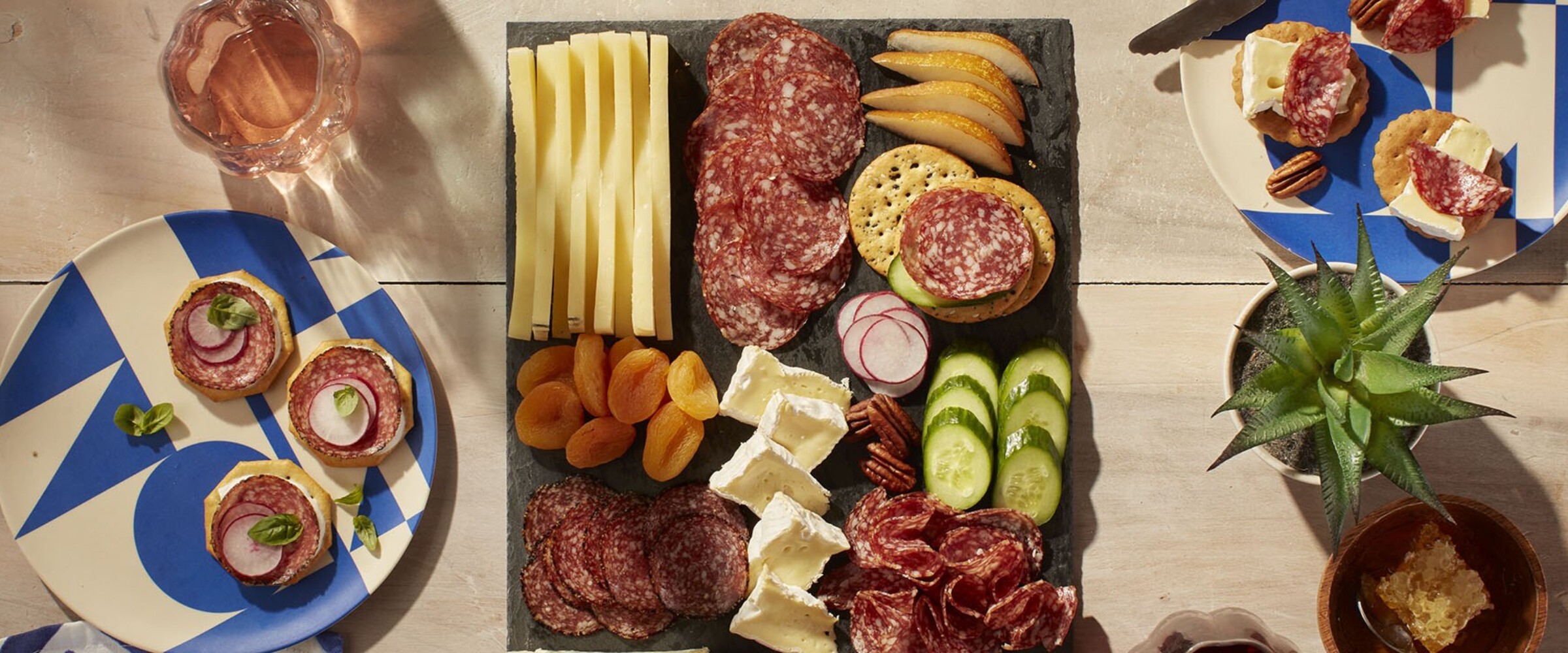 Charcuterie board with salami and cheese and fruit on a patio table