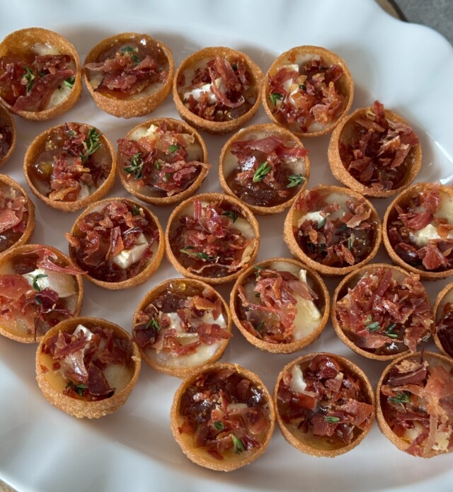 Dish of multiple mini brie and prosciutto cups