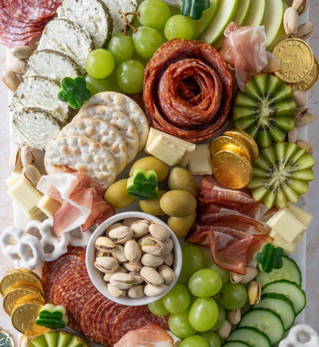 Charcuterie board filled with green and white themed food items for St. Patrick's day