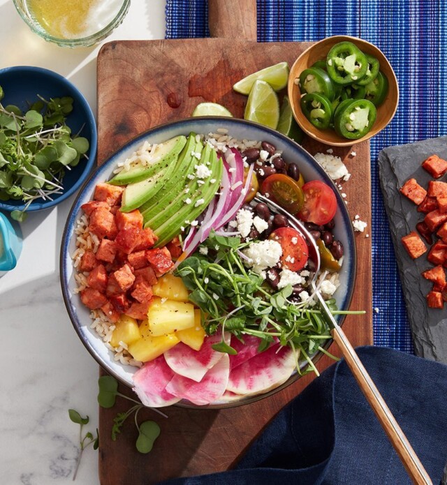 Chorizo, rice, avocado in a blue bowl on a cutting board