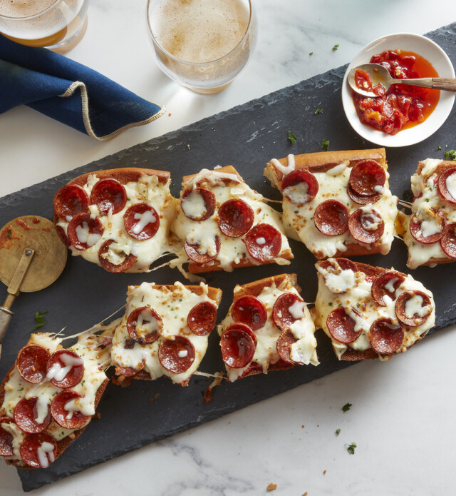 Garlic bread pizza with pepperoni on a black slate