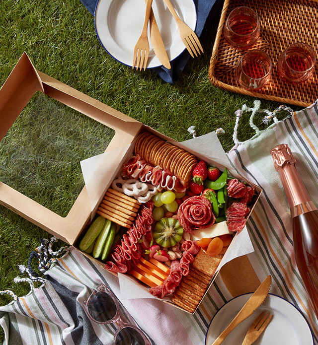 charcuterie grazing box on a picnic blanket
