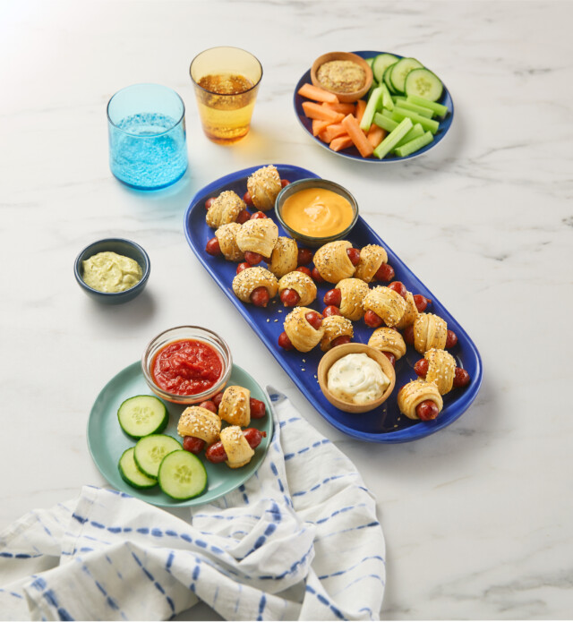 Platter of many mini pepperoni sticks wrapped in a pastry.