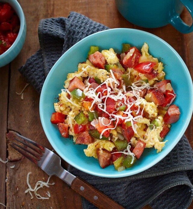 Scrambled eggs with chorizo and vegetables in a blue bowl