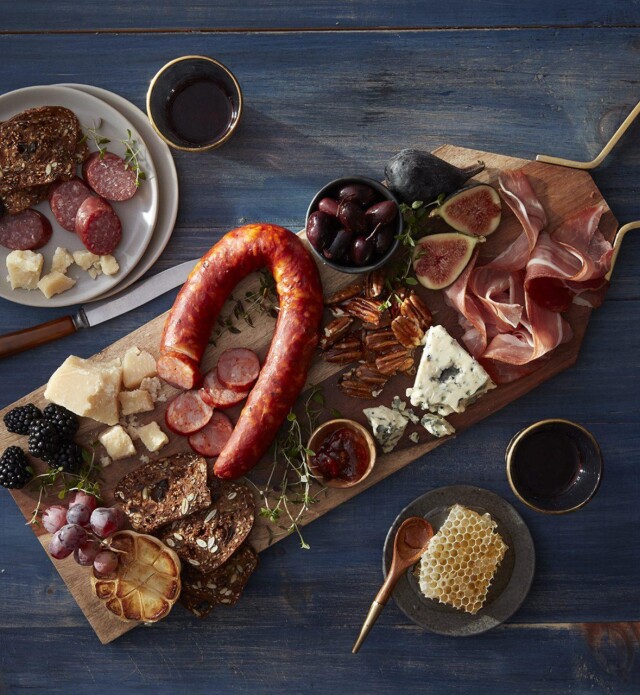 A charcuterie board made for date night with meat, cheese, fruits and wine