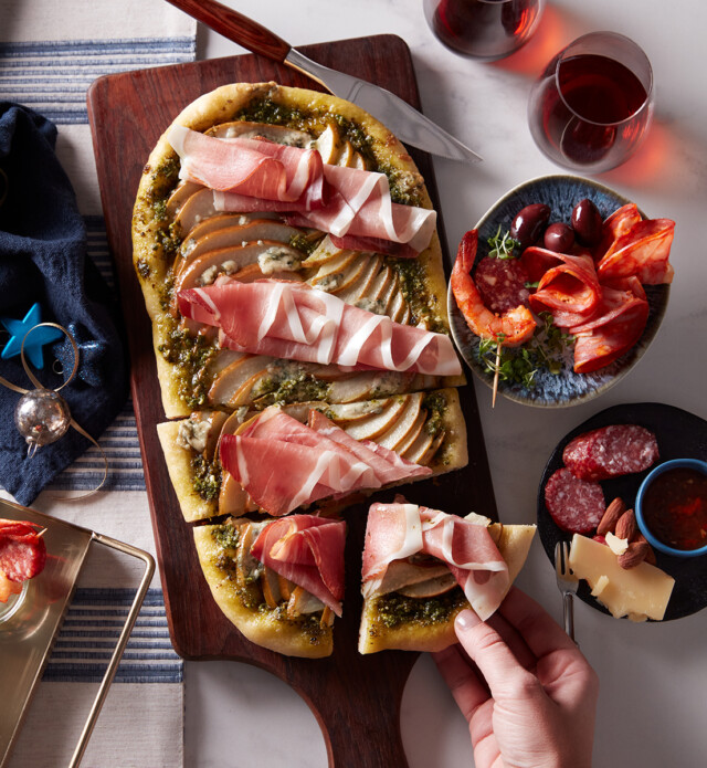 Prosciutto and pear flatbread on a board with holiday decorations