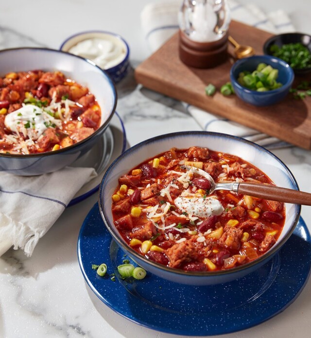 Two bowls of chili with sausage