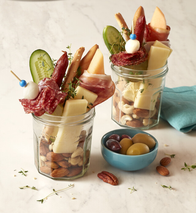 charcuterie inside a mason jar with meat, cheese and nuts
