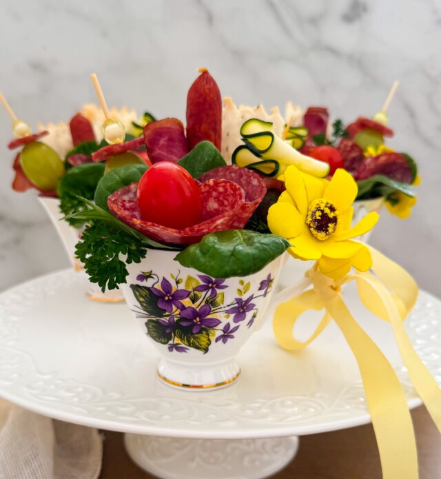 Tea cups with charcuterie items inside of it