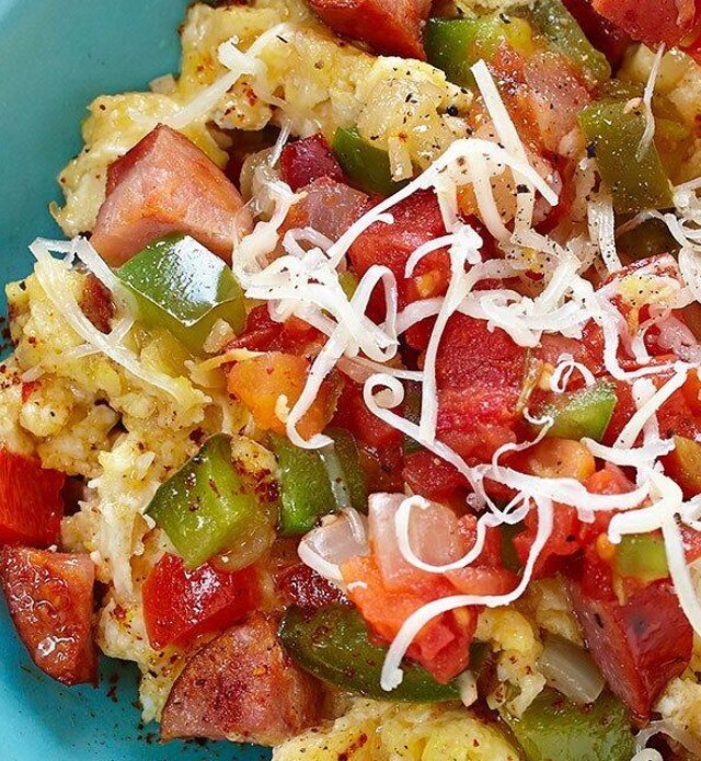 Scrambled eggs with chorizo and vegetables in a blue bowl