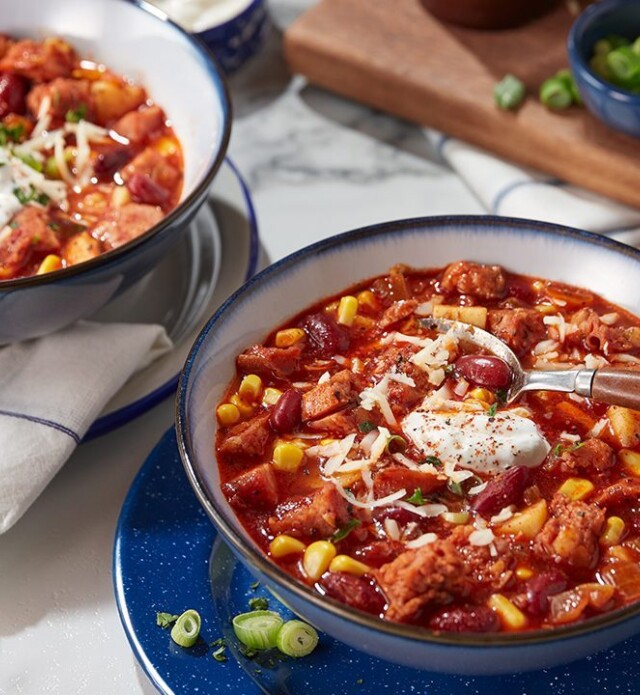 Two bowls of chili with sausage